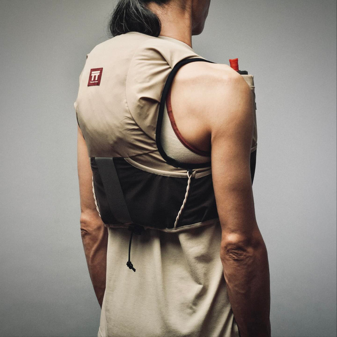 Group of trail runners at the race start wearing hydration vests and race bibs.