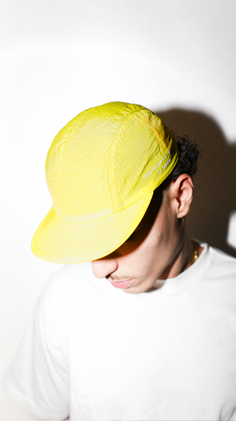 Lievre Running yellow performance running cap, lightweight technical fabric with adjustable back cord and “Engineered for the Art of Running” text on the side panel.