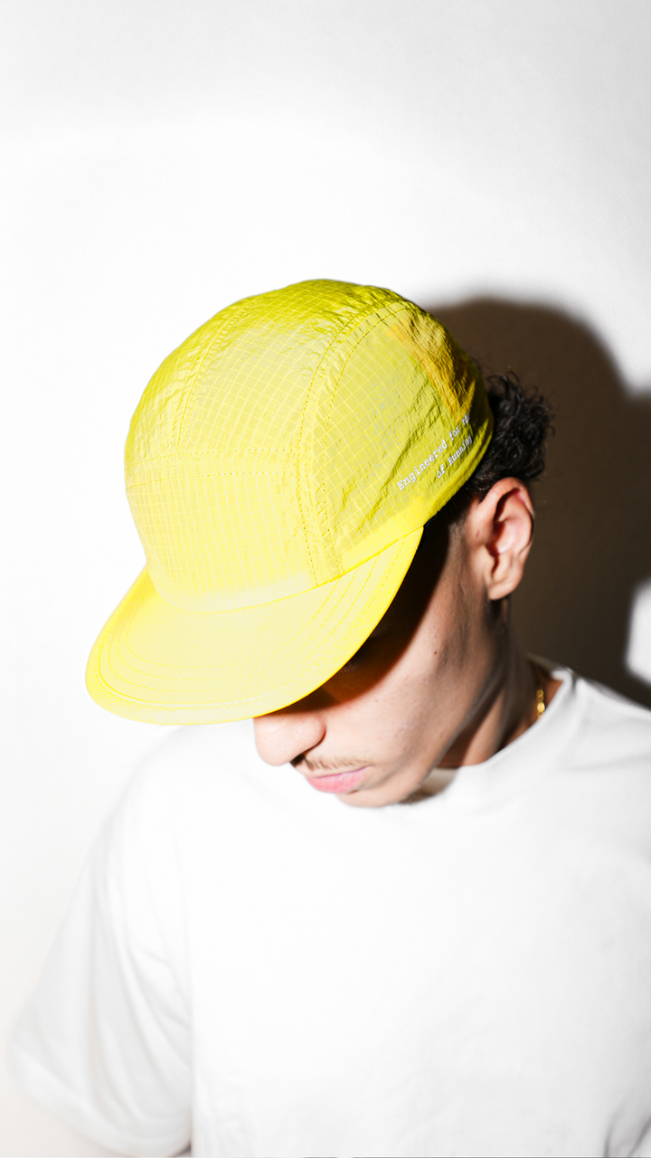 Lievre Running yellow performance running cap, lightweight technical fabric with adjustable back cord and “Engineered for the Art of Running” text on the side panel.