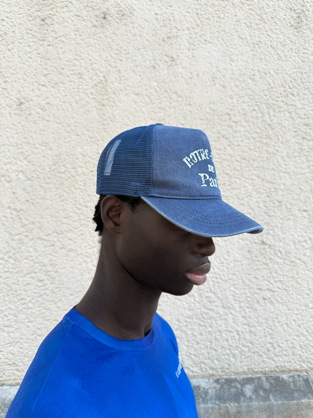 Washed Indigo Mesh Cap by Lievre Running featuring 5 panels and adjustable snapback with vintage Notre-Dame de Paris design.