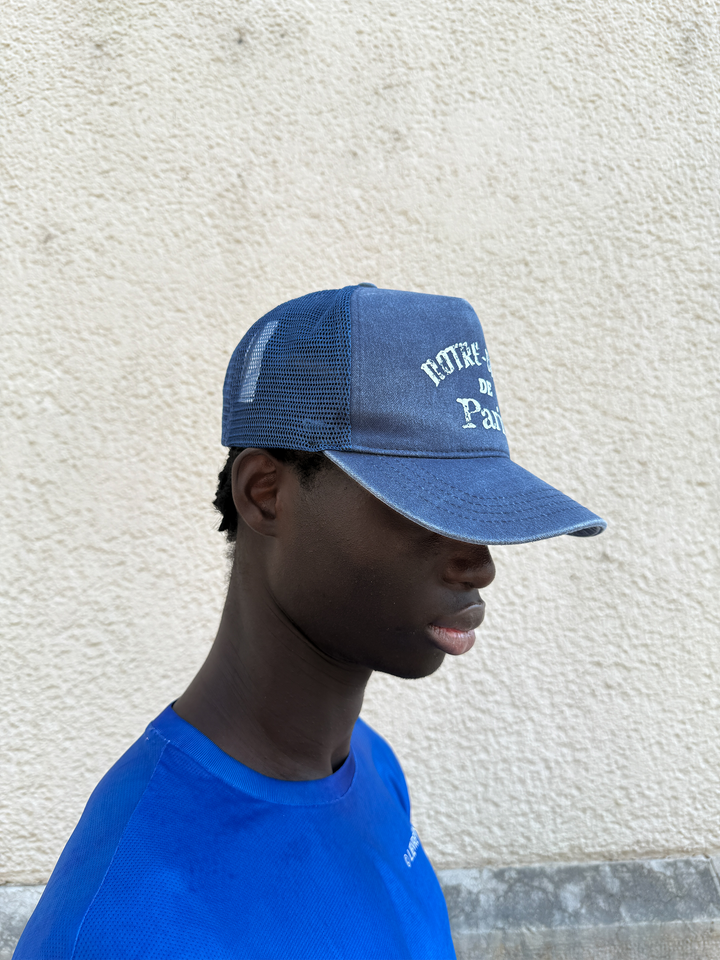 Washed Indigo Mesh Cap by Lievre Running featuring 5 panels and adjustable snapback with vintage Notre-Dame de Paris design.