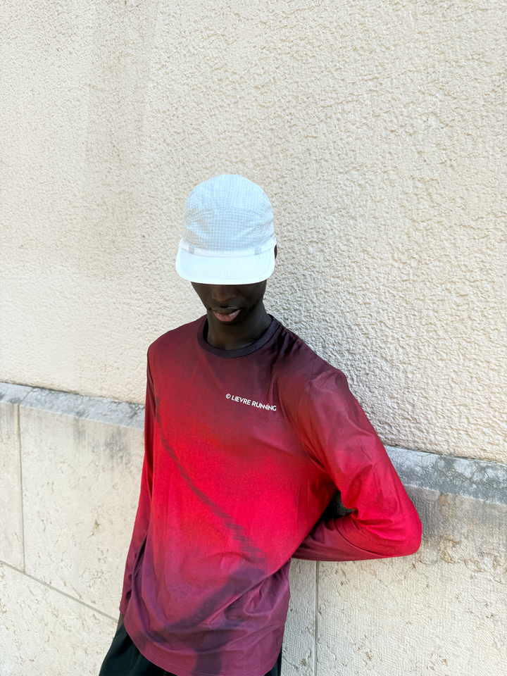 Lievre Running Art of Running White Cap showcasing its minimal design and ultra-lightweight fabric, ideal for runners.