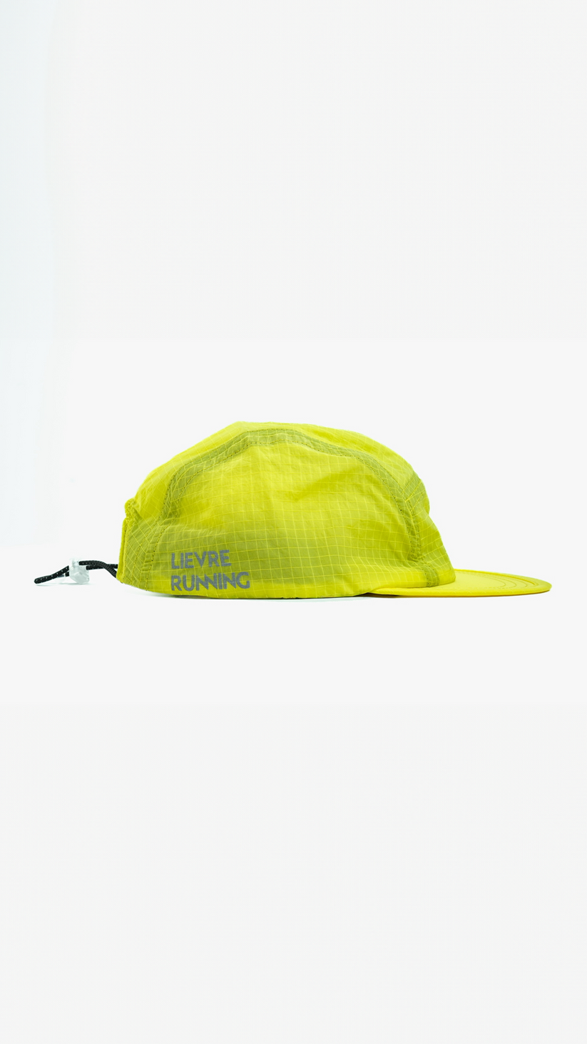 Lievre Running yellow performance running cap, lightweight technical fabric with adjustable back cord and “Engineered for the Art of Running” text on the side panel.