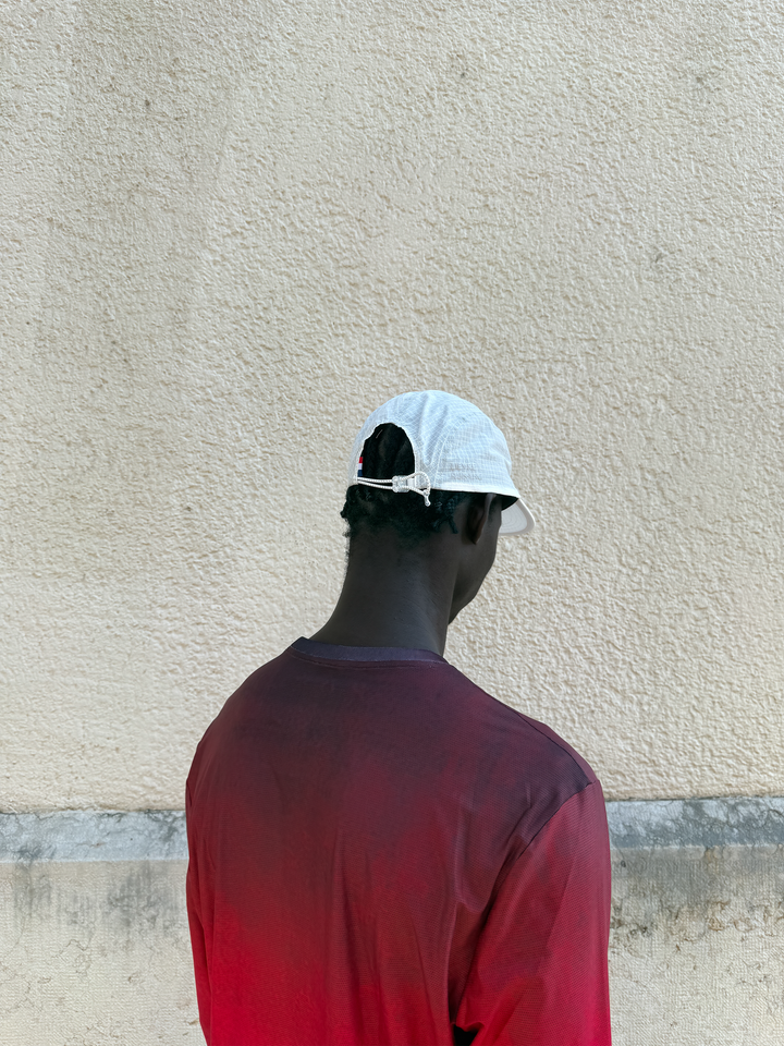 Lievre Running Art of Running White Cap showcasing its minimal design and ultra-lightweight fabric, ideal for runners.