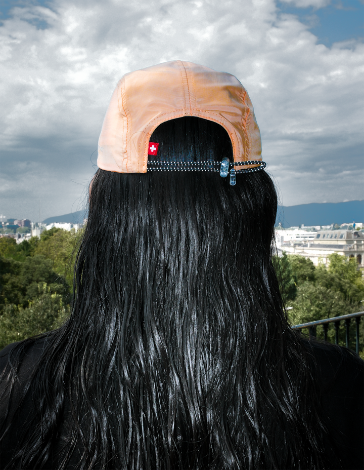 Lievre Running light salmon performance running cap, lightweight technical fabric with adjustable back cord and "Engineered for the Art of Running" text on the side panel.