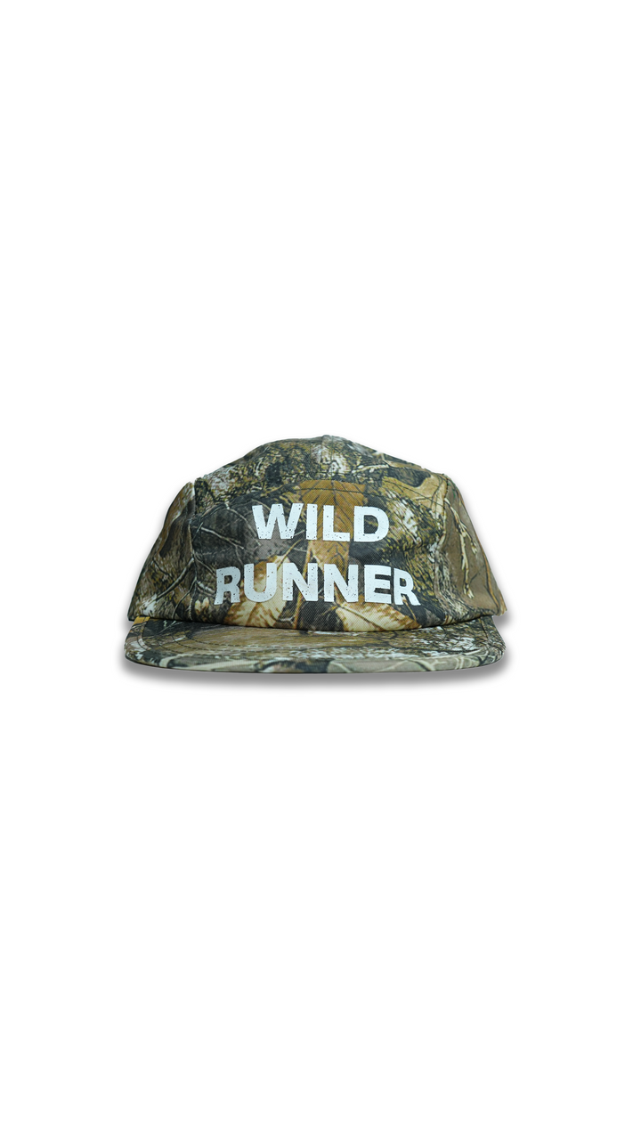 Lievre Running Wild Runner cap with camouflage print and bold “WILD-RUNNER” white text on front, five-panel silhouette with flat brim.