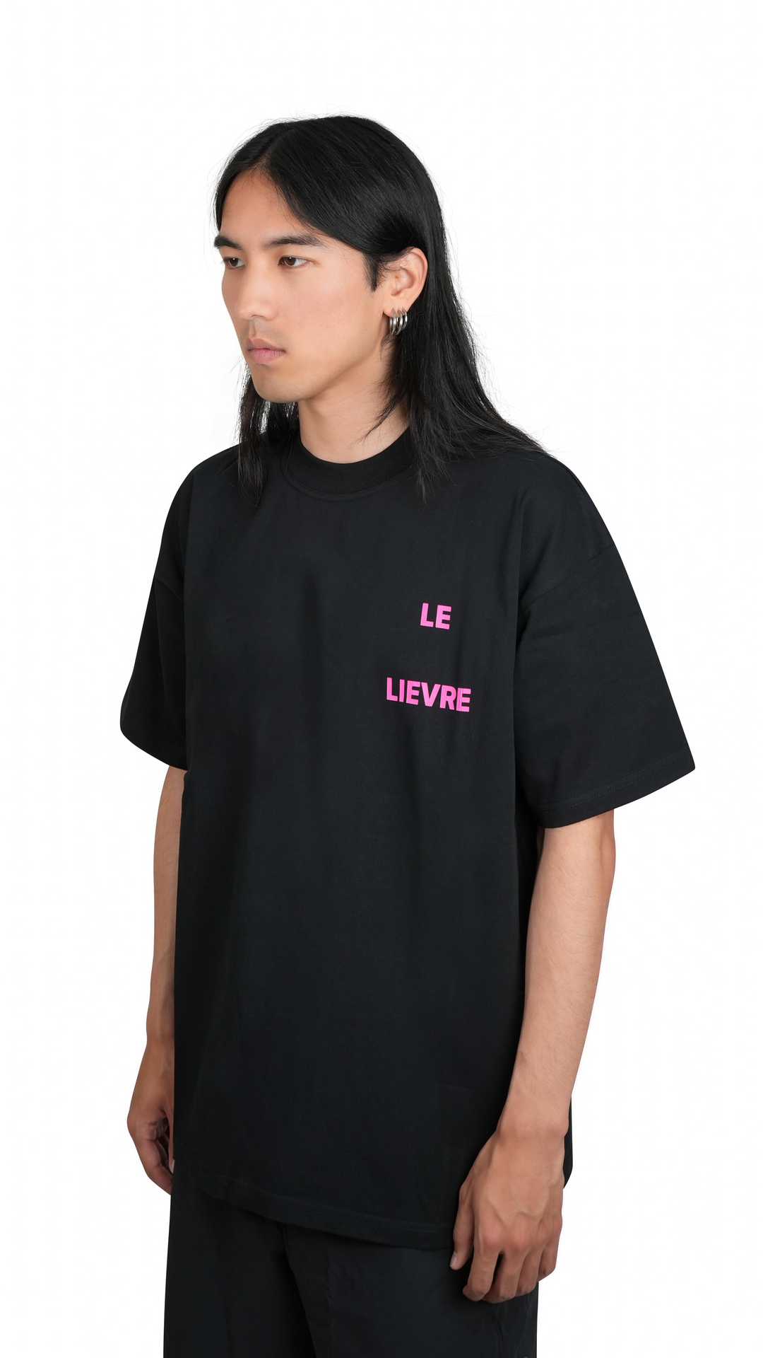 Lievre Running black cotton tee with oversized fit, featuring a bold pink graphic of a running hare on the back and subtle script detail near the hem.