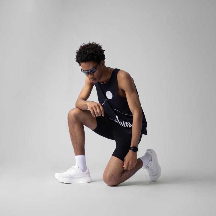 A black singlet featuring a breathable design for running and workouts, made from lightweight polyester and spandex.