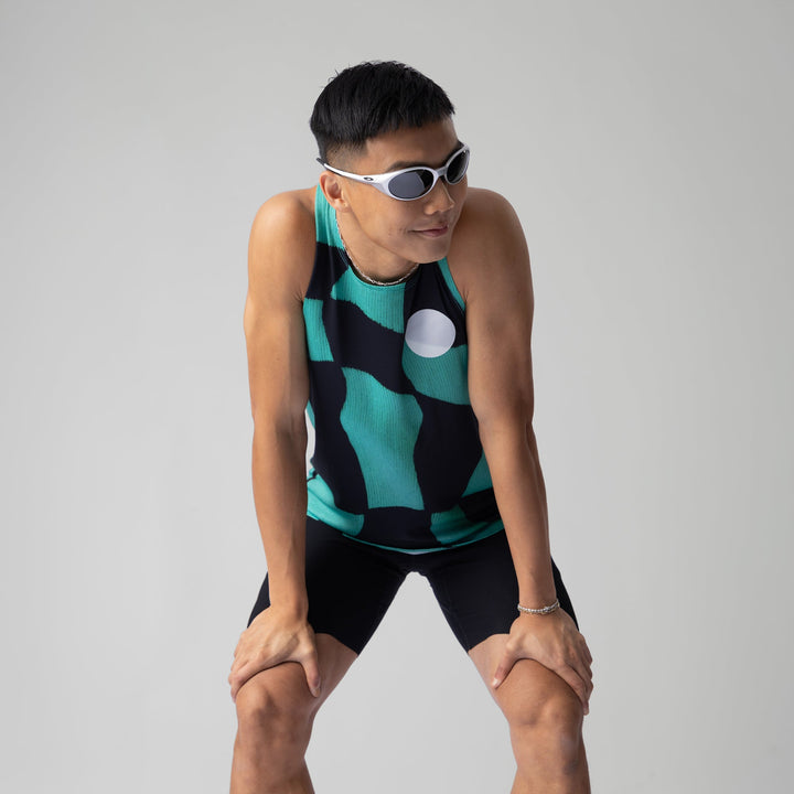 A woman wearing the Green Checker Singlet, showcasing its breathable design and checkered pattern, perfect for running and outdoor activities.