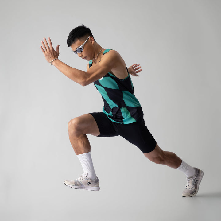 A woman wearing the Green Checker Singlet, showcasing its breathable design and checkered pattern, perfect for running and outdoor activities.