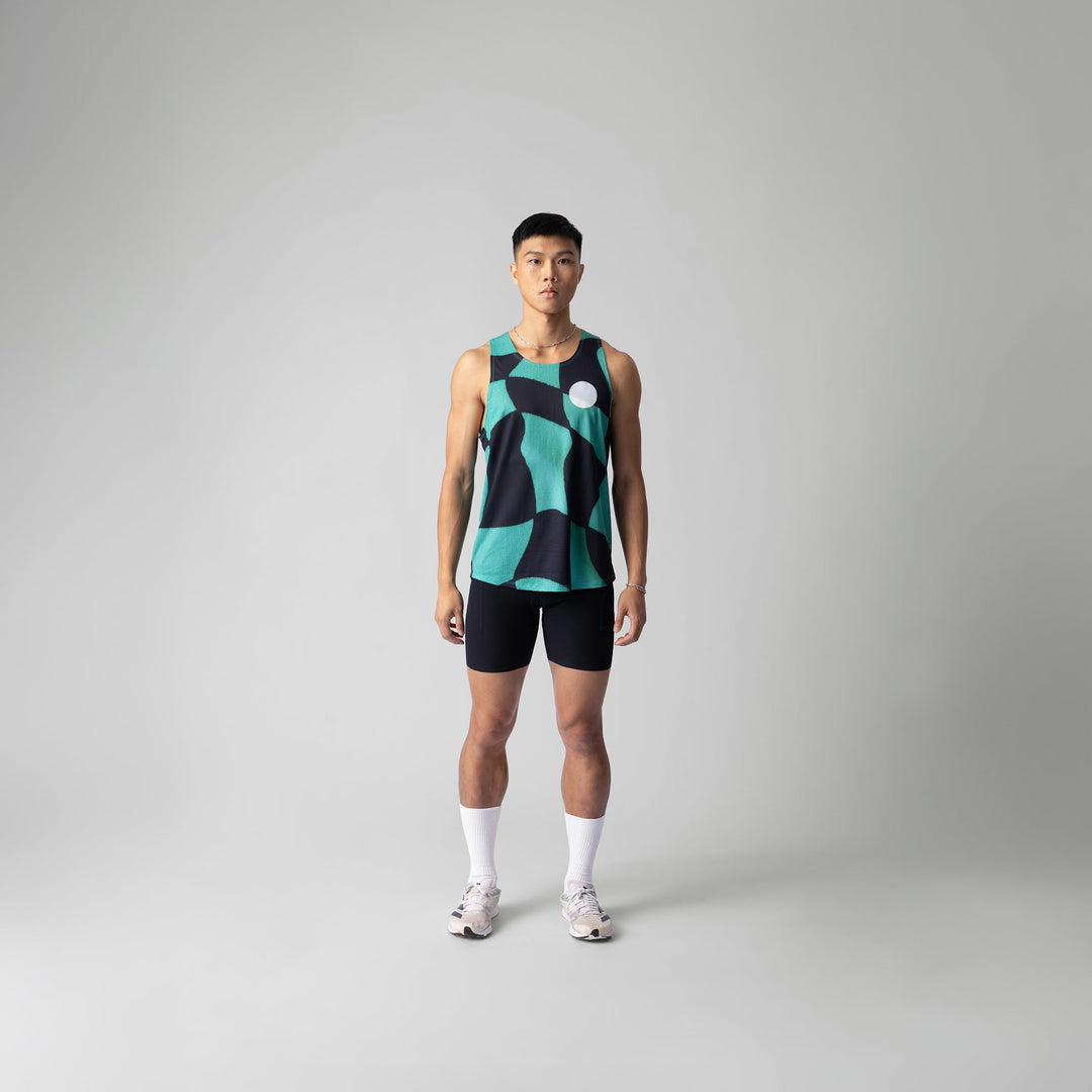 A woman wearing the Green Checker Singlet, showcasing its breathable design and checkered pattern, perfect for running and outdoor activities.