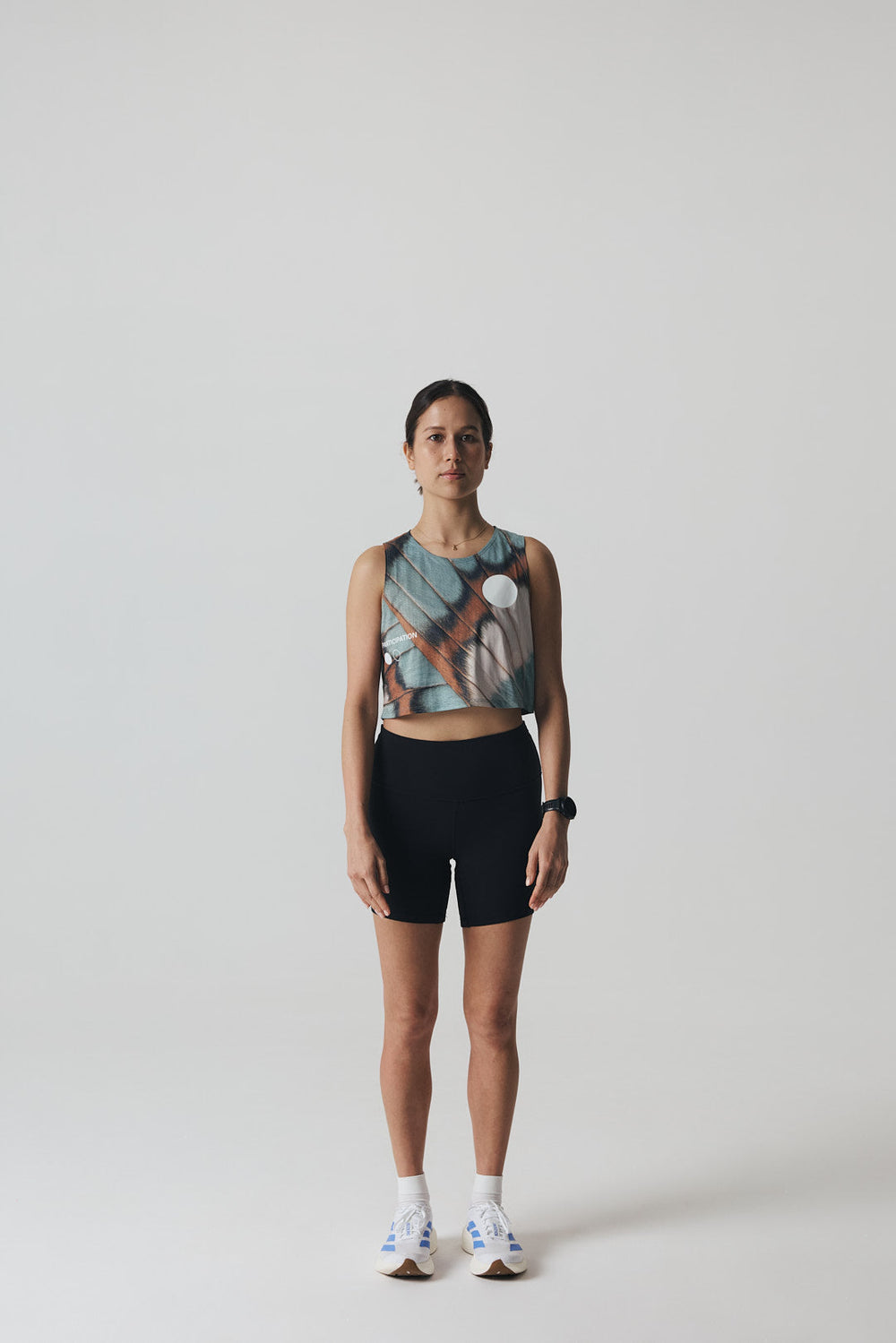 Participation butterfly crop singlet, breathable mesh, teal–tan wing print, white circle logo on chest.