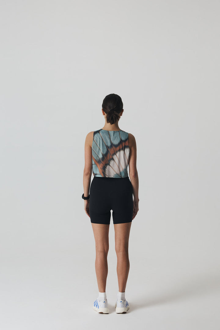 Participation butterfly crop singlet, breathable mesh, teal–tan wing print, white circle logo on chest.