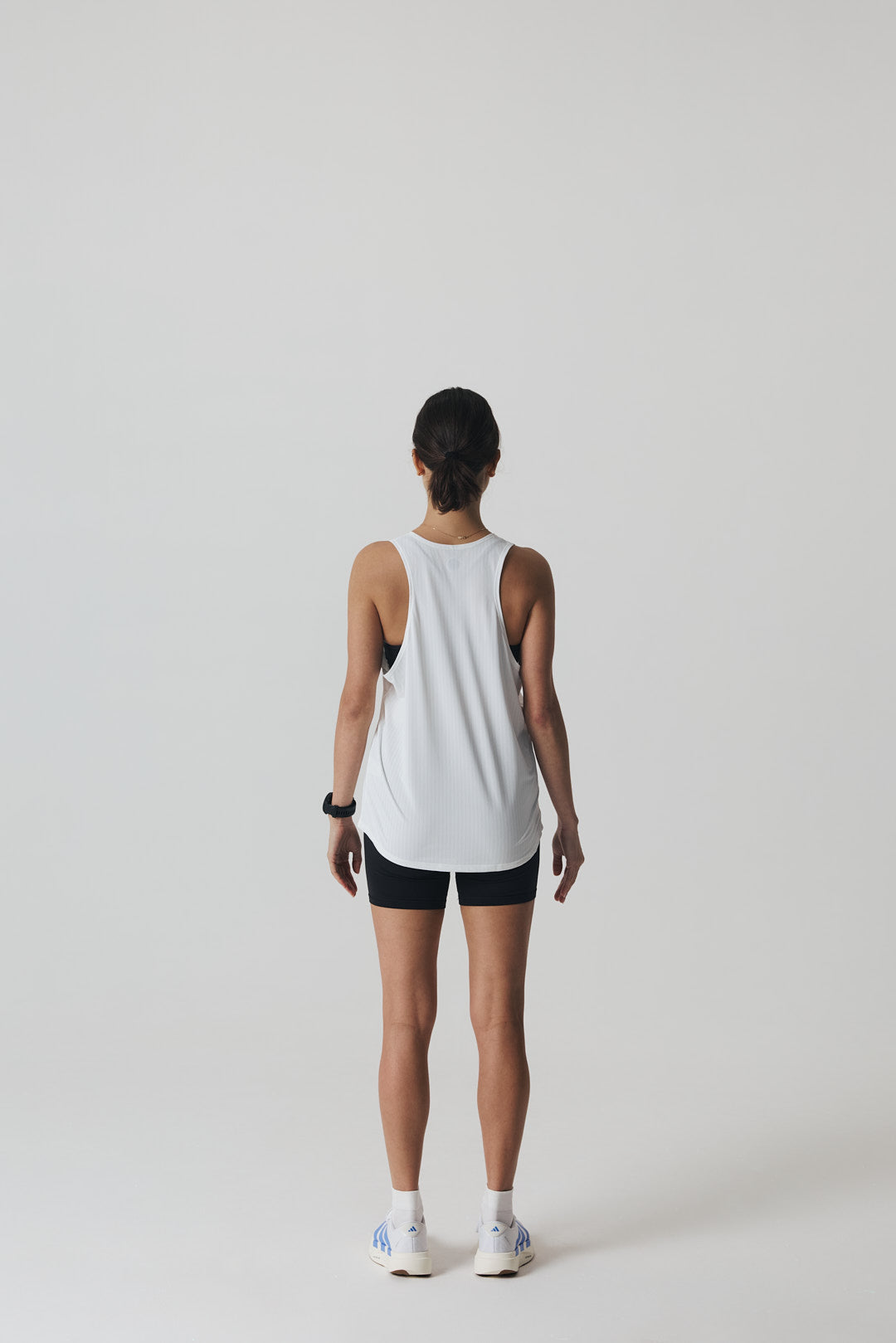 Participation black singlet, breathable mesh, white circle logo on chest.
