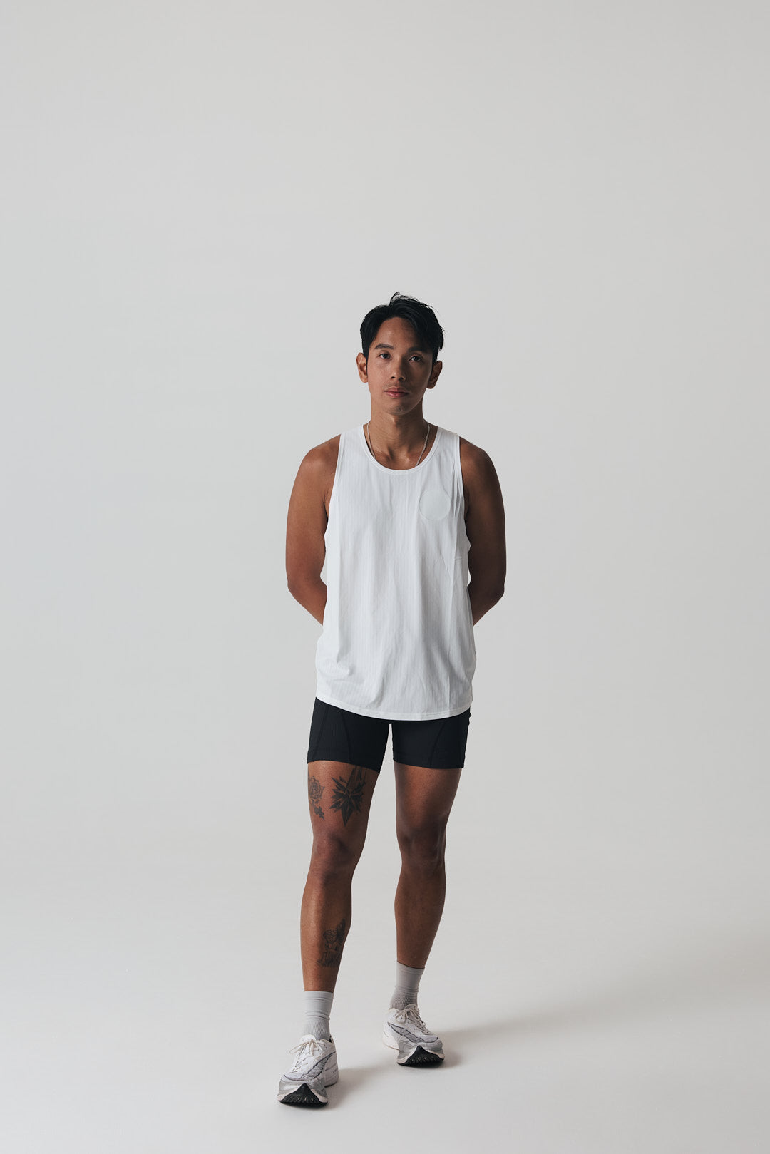 Participation black singlet, breathable mesh, white circle logo on chest.