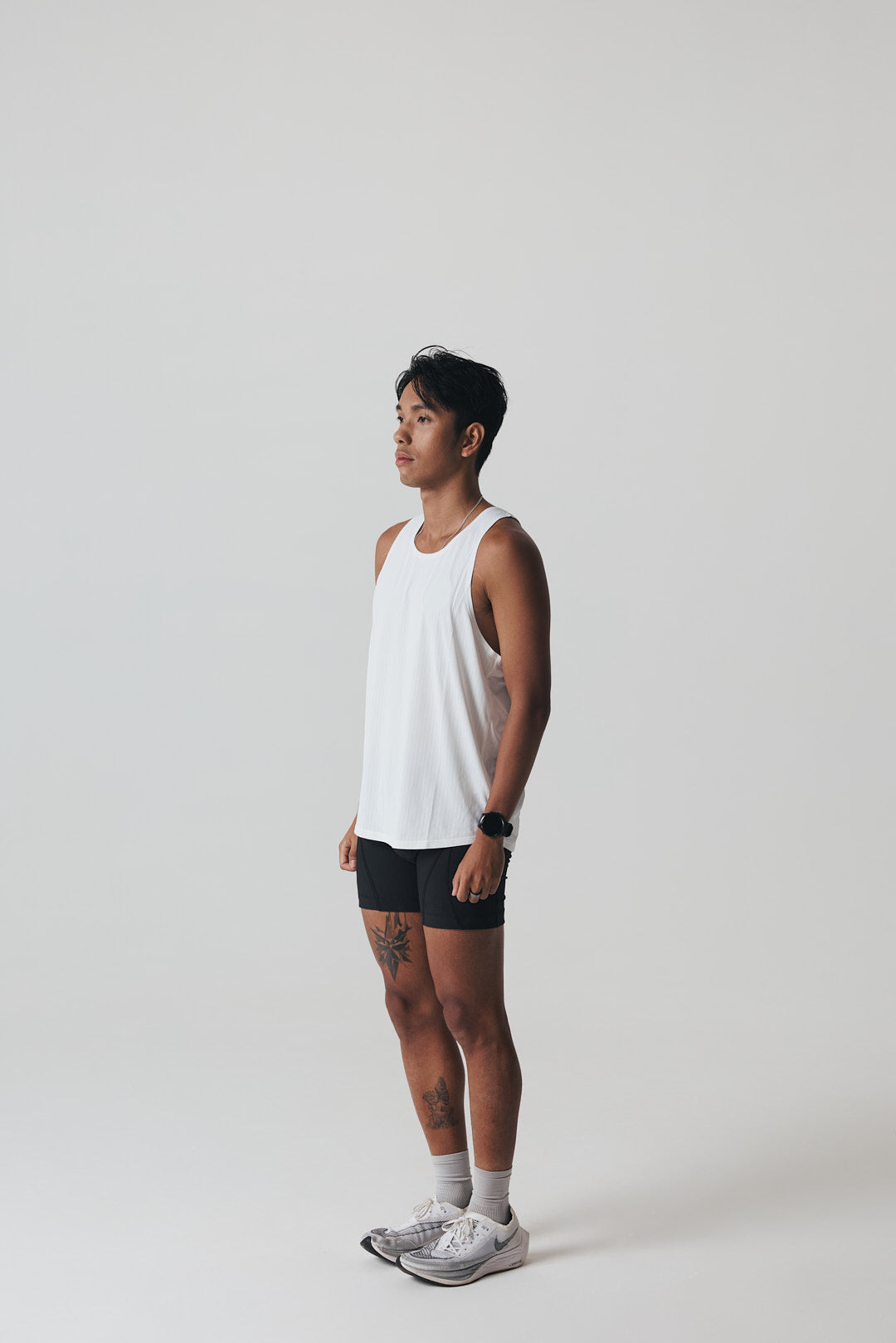 Participation black singlet, breathable mesh, white circle logo on chest.