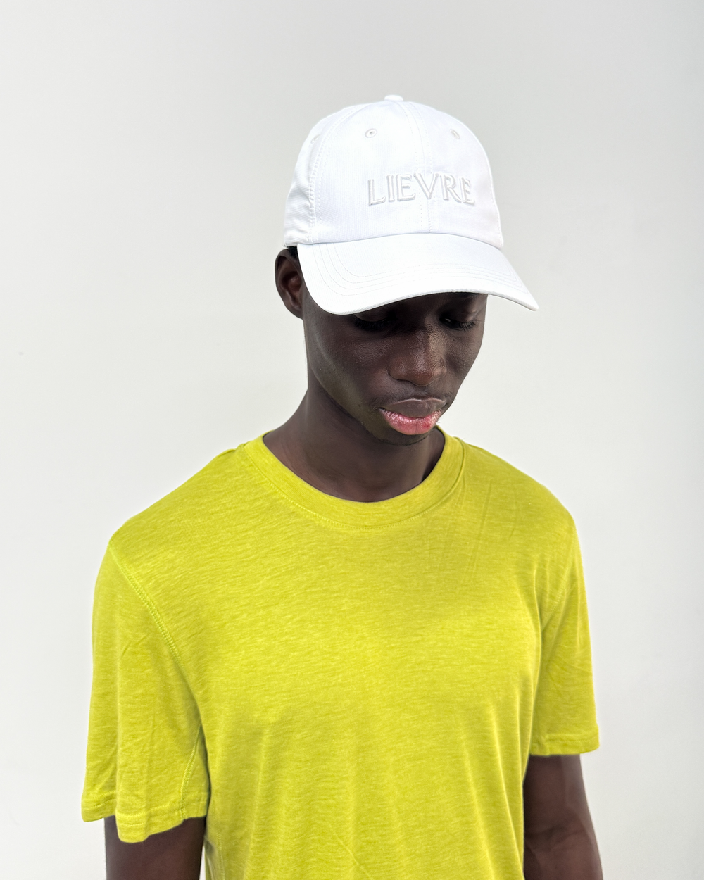 Lievre Running Signature White Cap, ultra-lightweight technical nylon construction with minimal design and adjustable back cord.