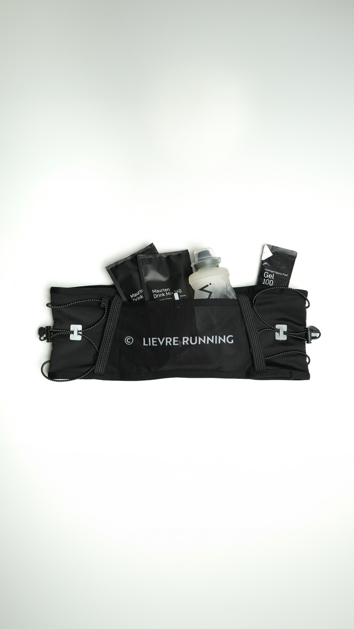 Lievre Running black ultra running belt, stretch technical fabric with multiple compartments, bungee cord system and white Lievre Running logo on front and back.