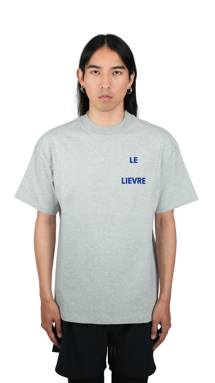 Lievre Running grey cotton tee with relaxed fit, featuring a large blue graphic of a running hare on the back and subtle script detail near the hem.