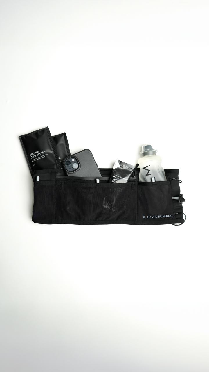 Lievre Running black ultra running belt, stretch technical fabric with multiple compartments, bungee cord system and white Lievre Running logo on front and back.