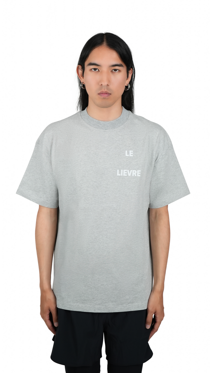 Lievre Running grey cotton tee with relaxed fit, featuring a large white graphic of a running hare on the back and subtle script detail near the hem.
