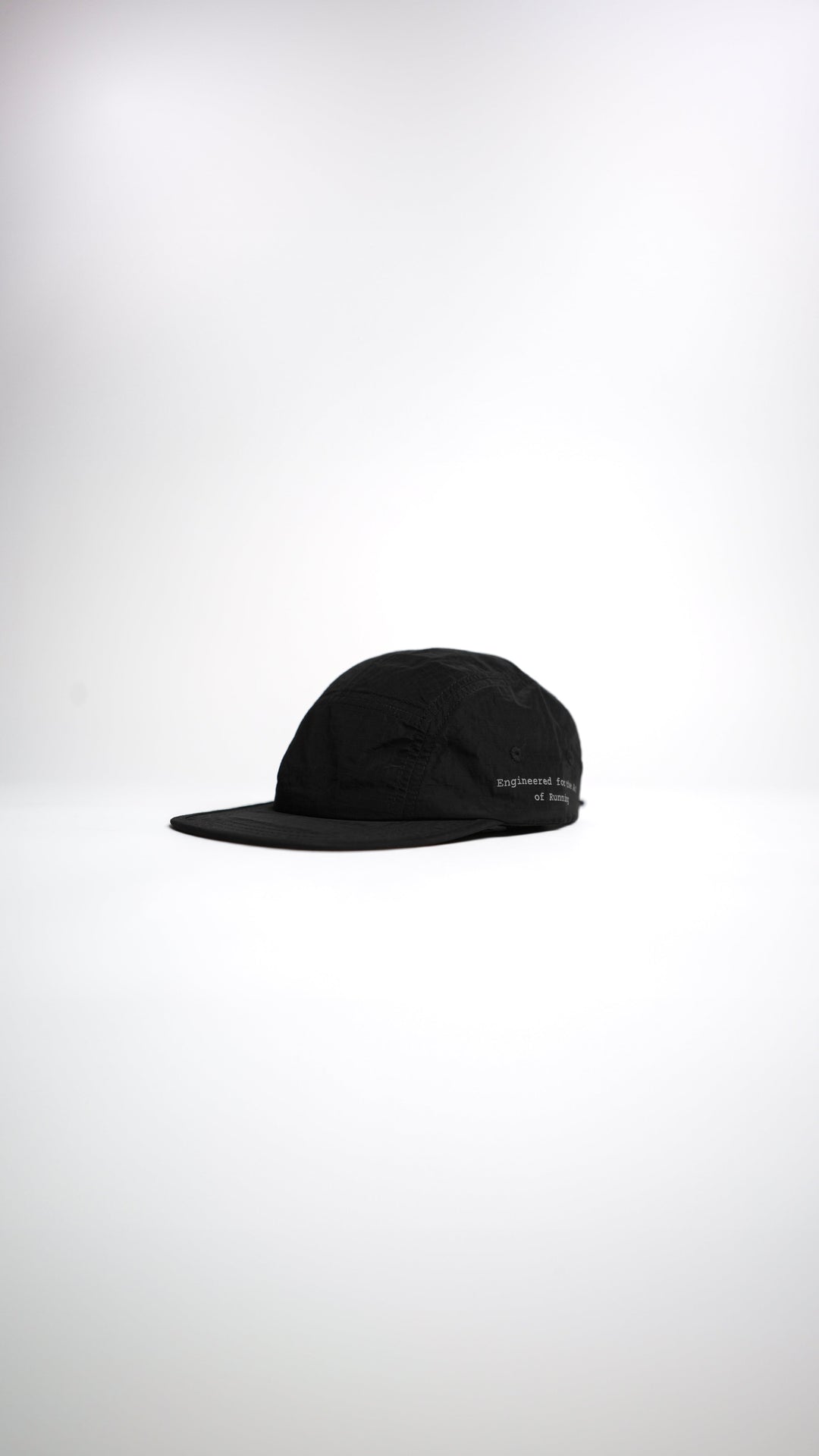 Lievre Running black performance running cap, lightweight technical fabric with adjustable back cord and “Engineered for the Art of Running” text on the side panel.