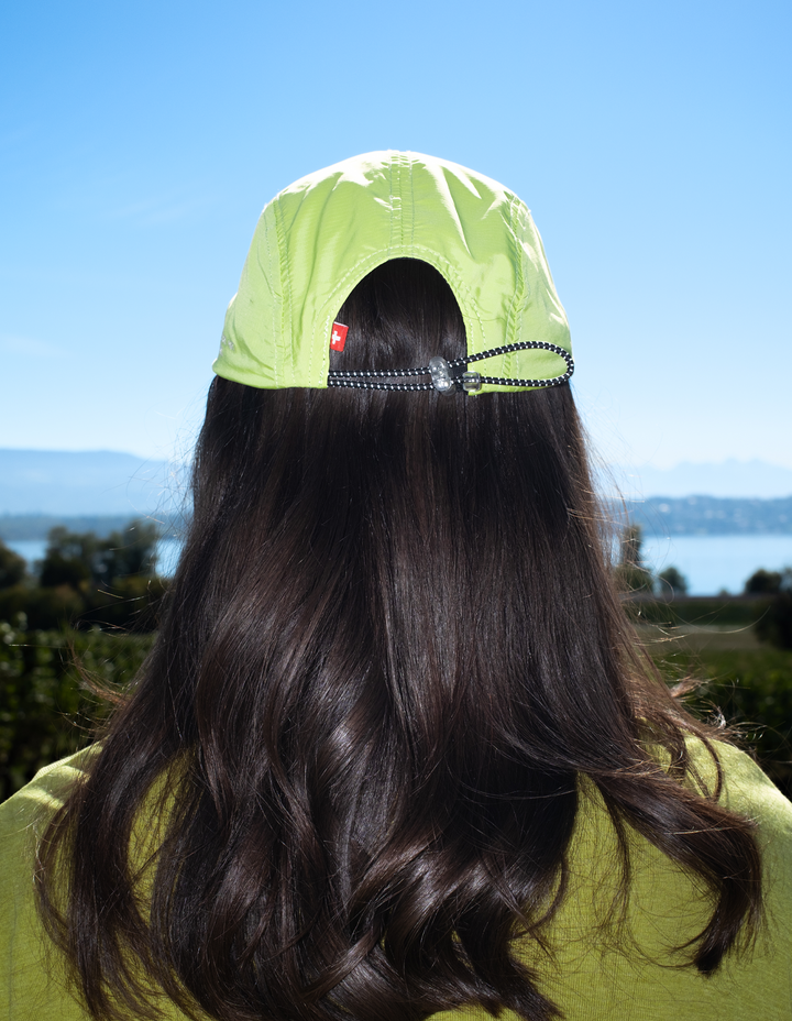 Lievre Running apple green performance running cap, lightweight technical fabric with adjustable back cord and "Engineered for the Art of Running" text on the side panel.
