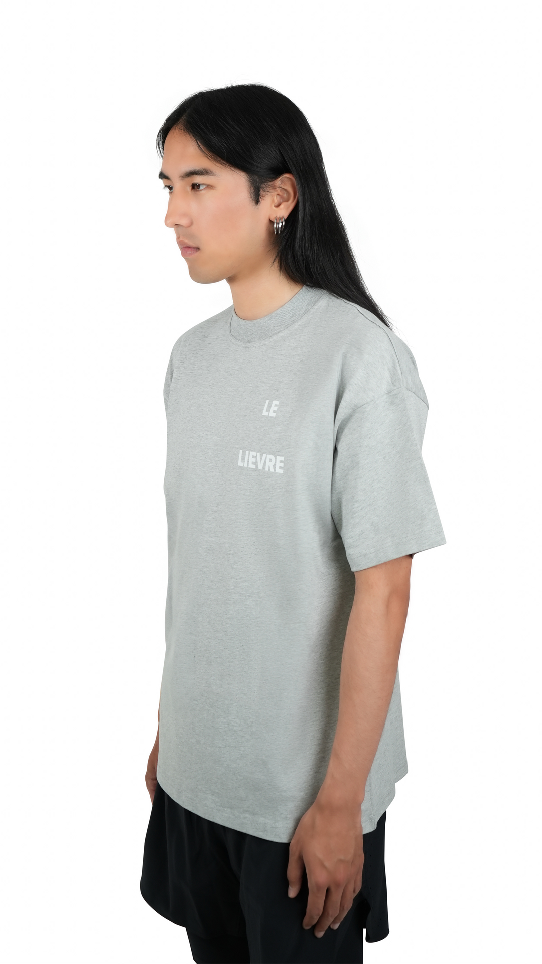 Lievre Running grey cotton tee with relaxed fit, featuring a large white graphic of a running hare on the back and subtle script detail near the hem.
