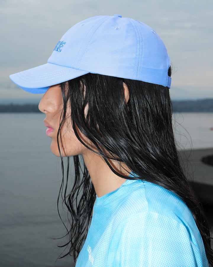 Lievre Running Signature Haze Blue Cap, ultra-lightweight nylon construction with DWR waterproof finish and minimal design, adjustable back strap.