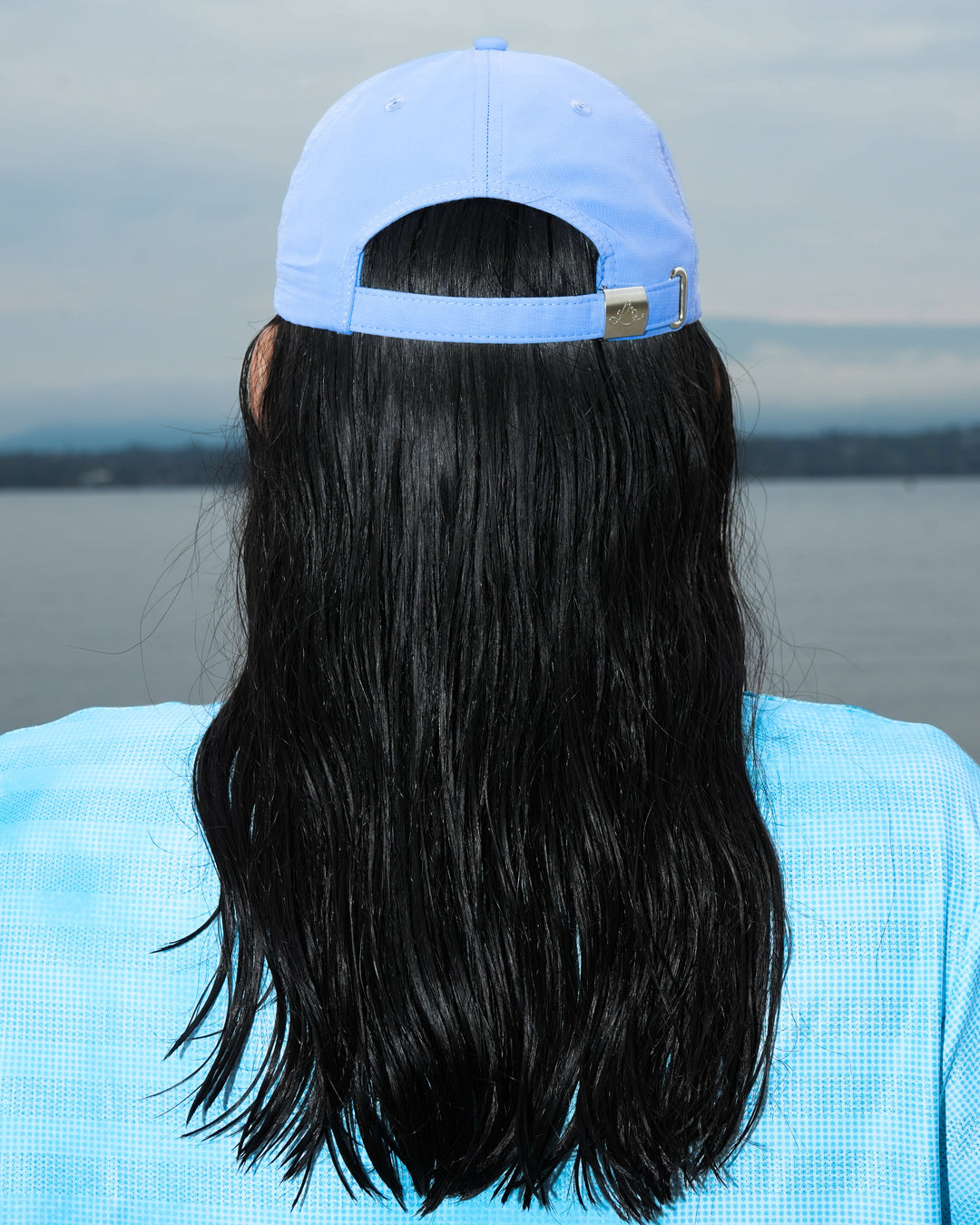 Lievre Running Signature Haze Blue Cap, ultra-lightweight nylon construction with DWR waterproof finish and minimal design, adjustable back strap.