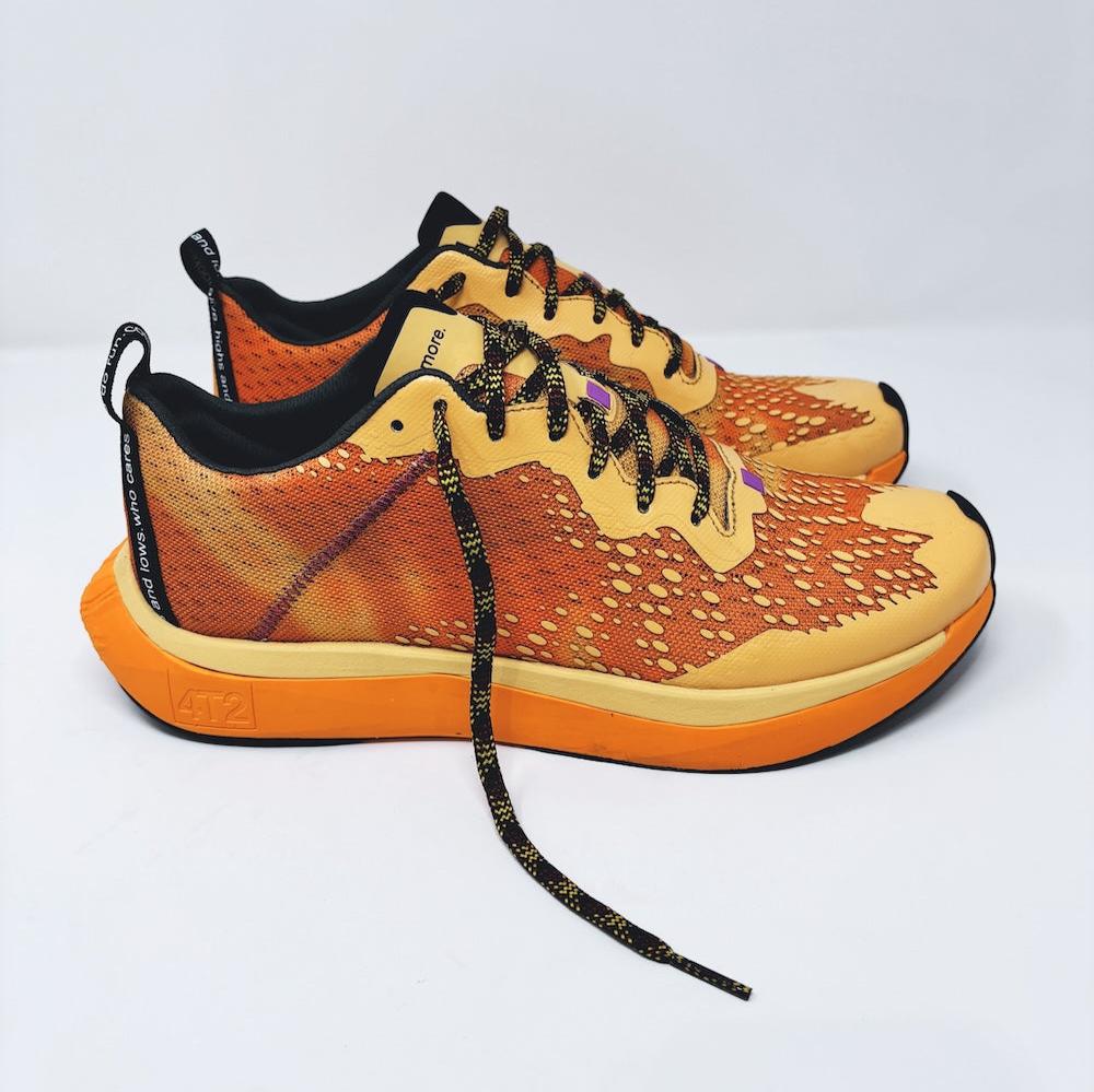 4T2 one more running shoe in orange, featuring a breathable upper and a durable rubber outsole designed for speed and traction.