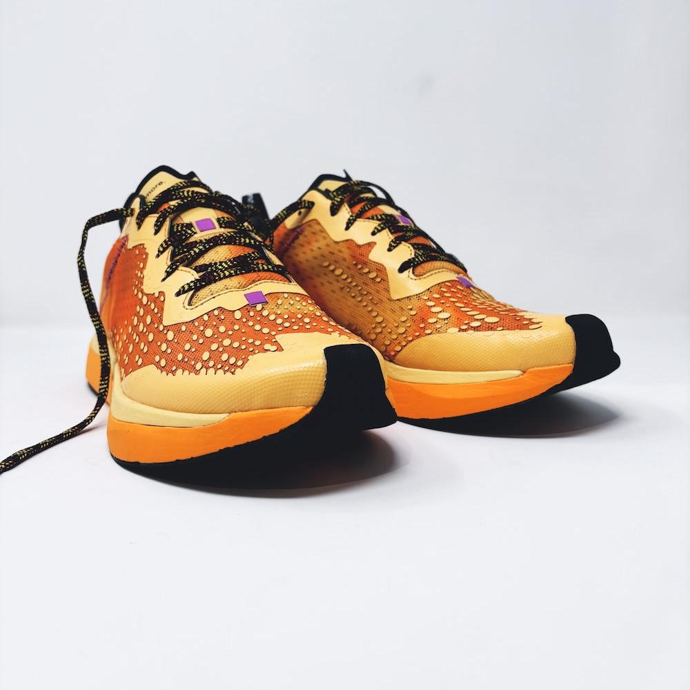 4T2 one more running shoe in orange, featuring a breathable upper and a durable rubber outsole designed for speed and traction.