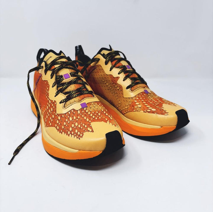 4T2 one more running shoe in orange, featuring a breathable upper and a durable rubber outsole designed for speed and traction.