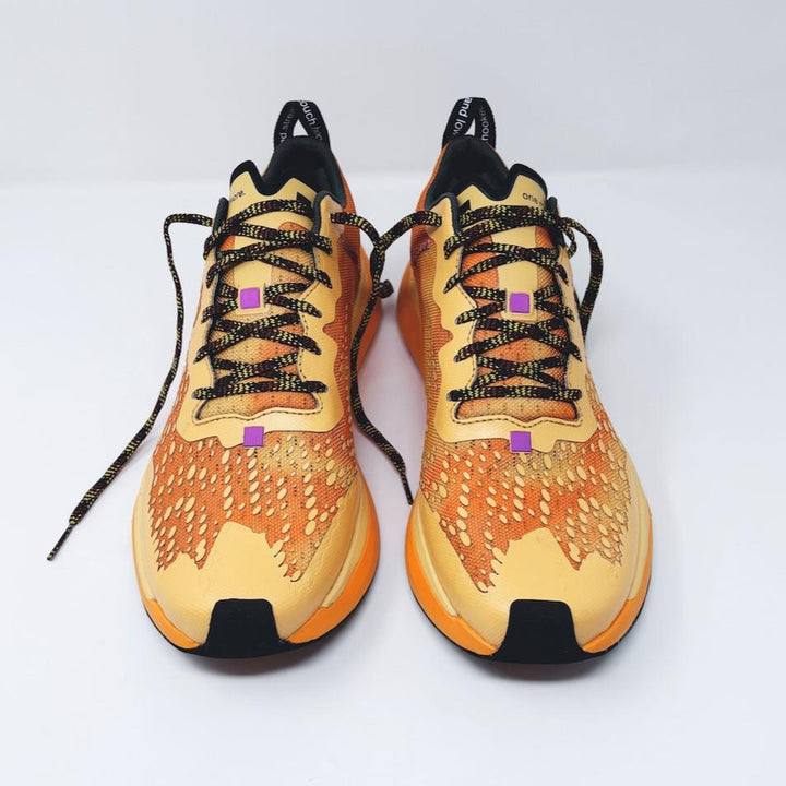 4T2 one more running shoe in orange, featuring a breathable upper and a durable rubber outsole designed for speed and traction.