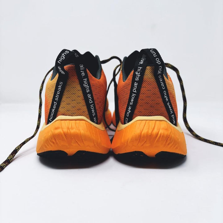 4T2 one more running shoe in orange, featuring a breathable upper and a durable rubber outsole designed for speed and traction.