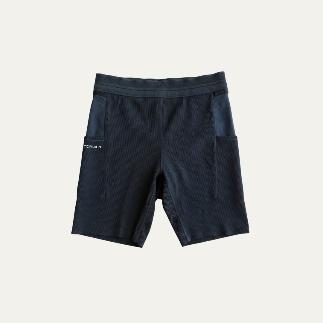 7.5-inch running tights from Participation, supportive compression design with multiple storage pockets for long-distance runs, photographed in a neutral studio setting.