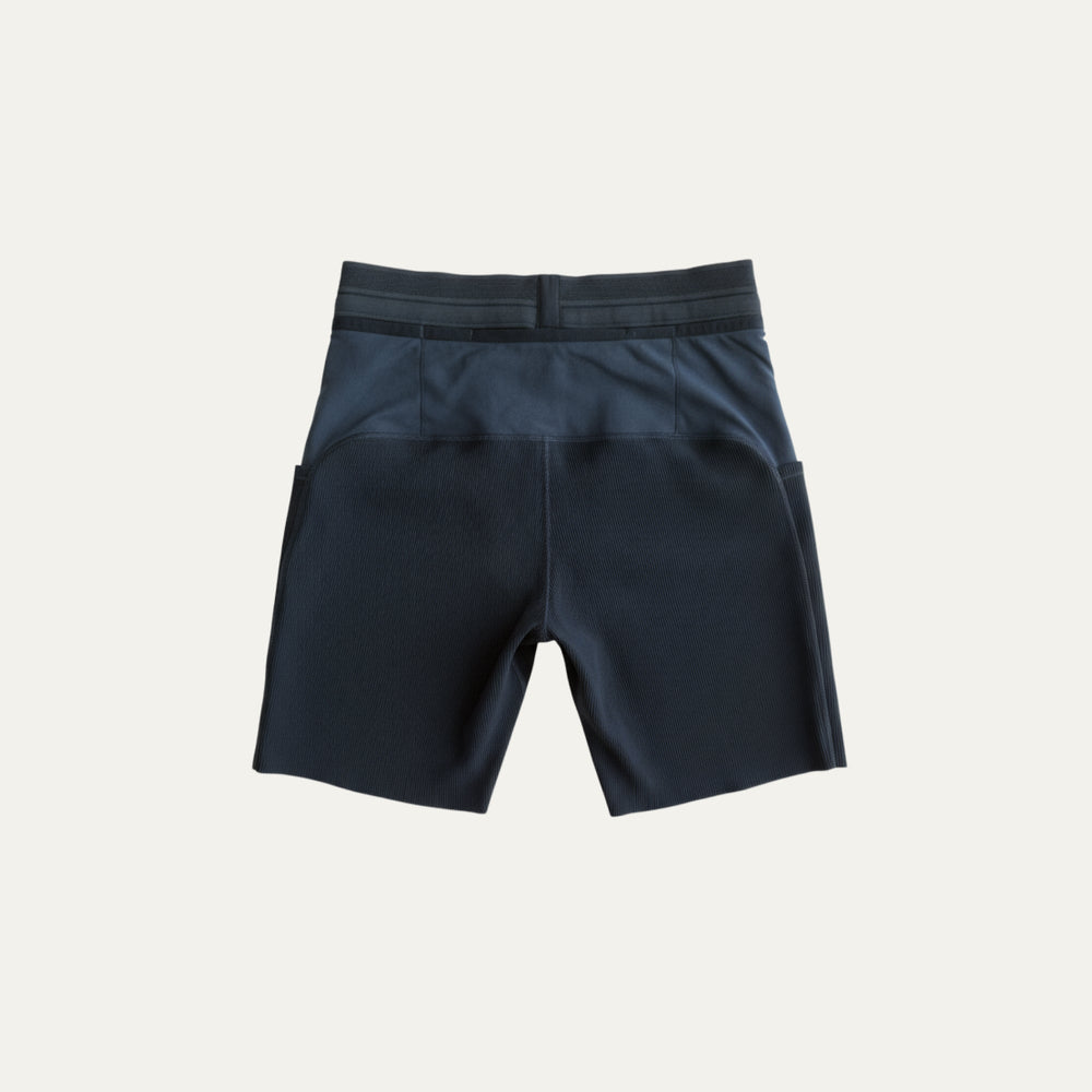 7.5-inch running tights from Participation, supportive compression design with multiple storage pockets for long-distance runs, photographed in a neutral studio setting.