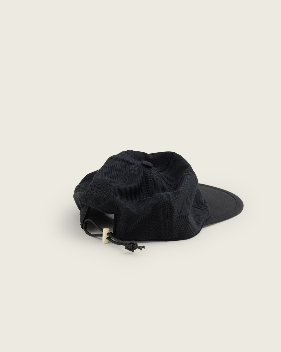 6-panel mesh running cap in Buttercup and Black from Sysum, lightweight construction with soft foam bill and adjustable back strap visible, photographed in a neutral studio setting.