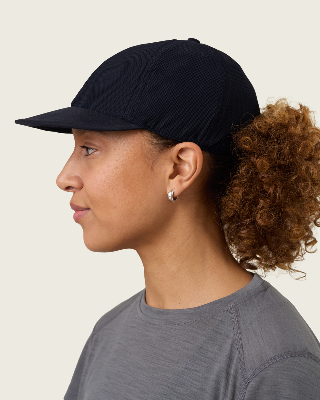 6-panel mesh running cap in Neutral and Black from Sysum, lightweight construction with soft foam bill and adjustable back strap visible, photographed in a neutral studio setting.