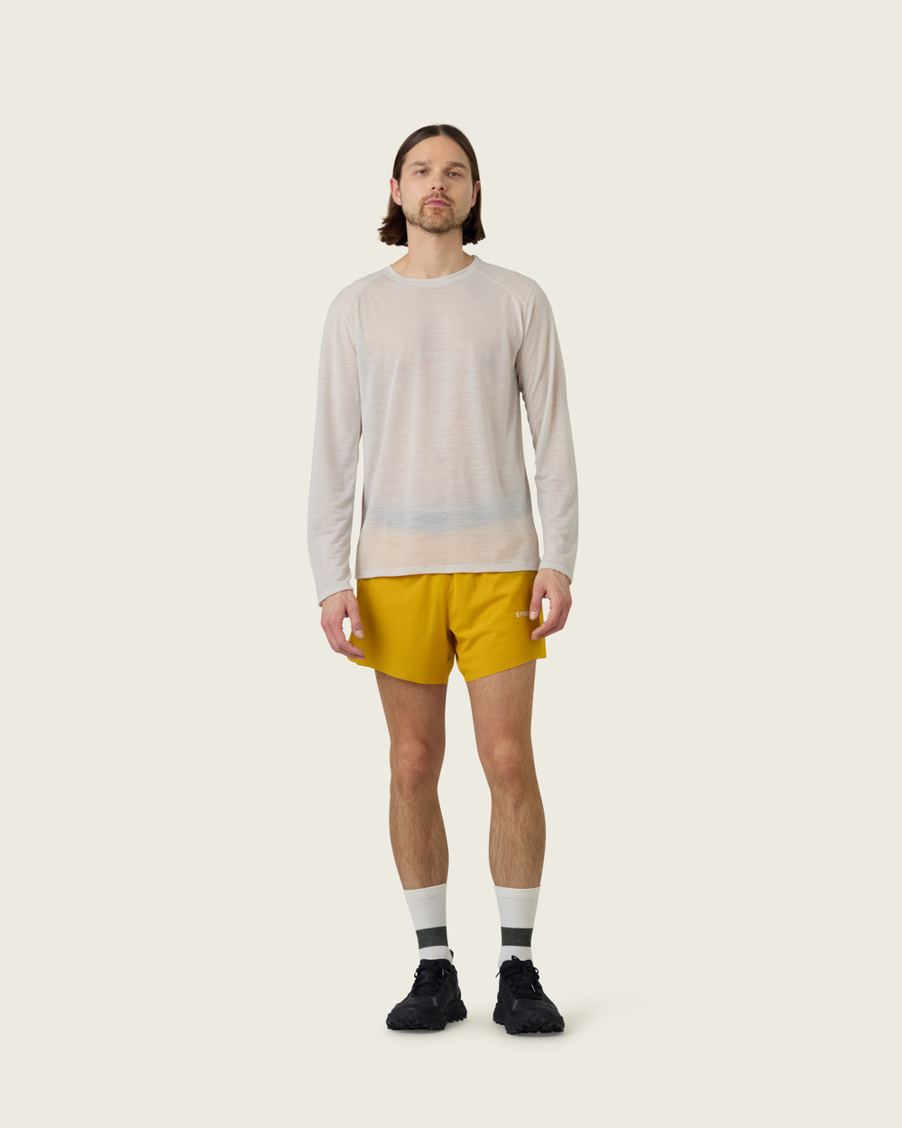 Men’s ultra-light merino long-sleeve running top in Pebble from Sysum, fine knit texture visible, photographed in a neutral studio setting.