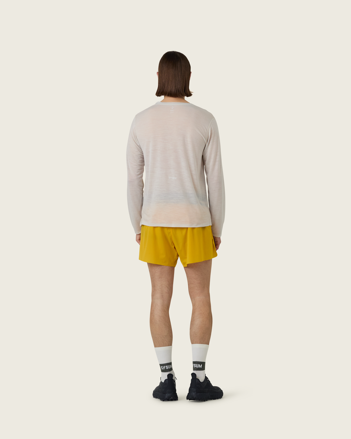 Men’s ultra-light merino long-sleeve running top in Pebble from Sysum, fine knit texture visible, photographed in a neutral studio setting.