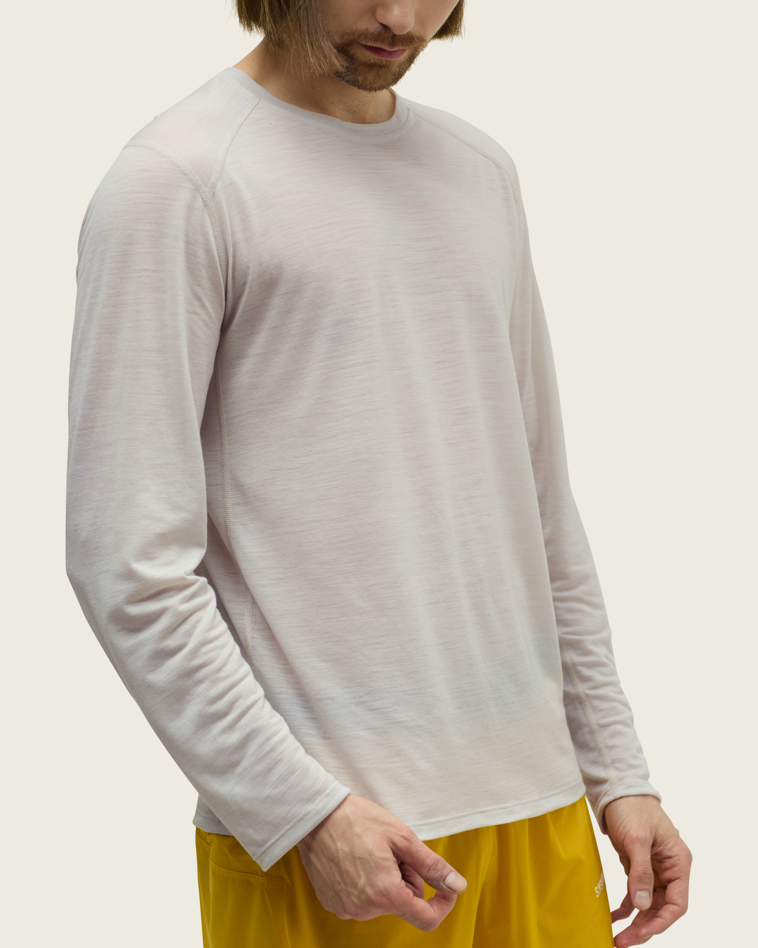 Men’s ultra-light merino long-sleeve running top in Pebble from Sysum, fine knit texture visible, photographed in a neutral studio setting.