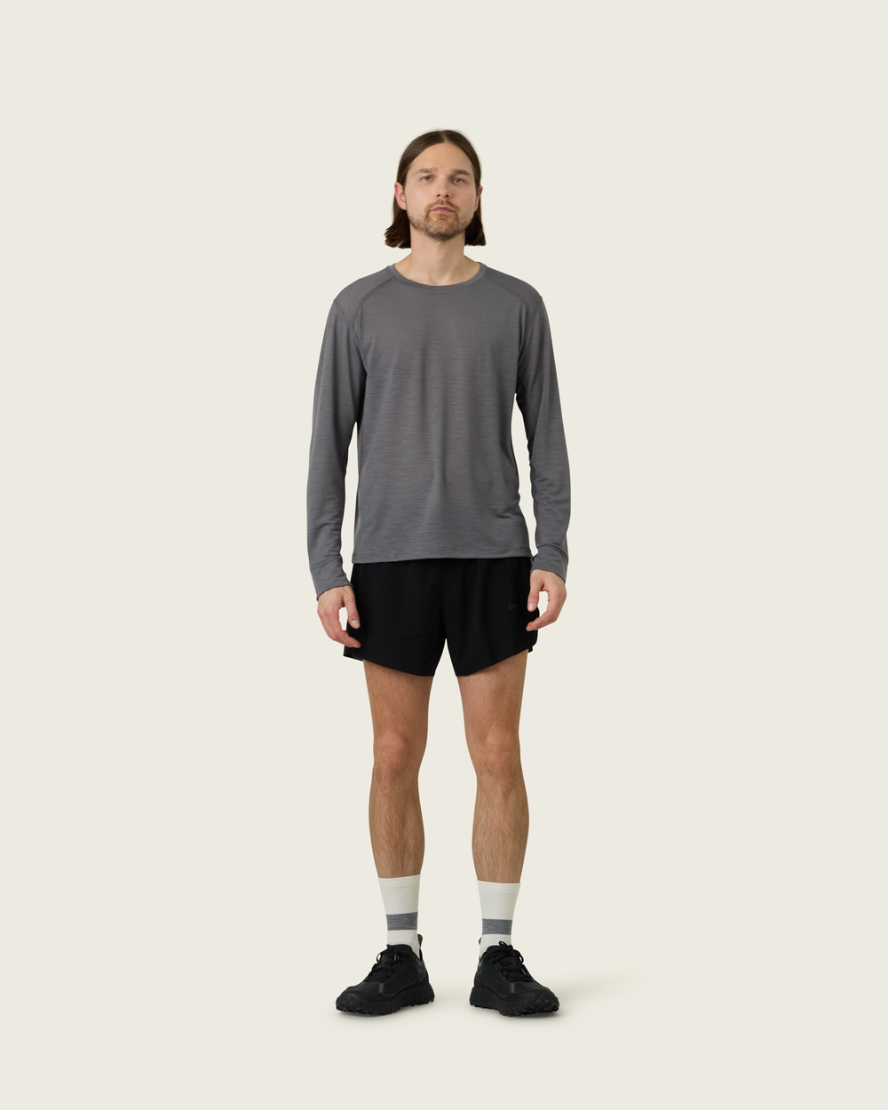 Men’s merino long-sleeve running top in Slate from Sysum, lightweight knit visible, photographed in a neutral studio setting.