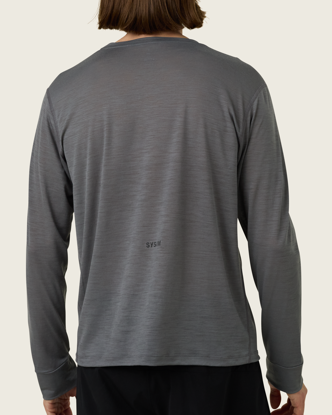 Men’s merino long-sleeve running top in Slate from Sysum, lightweight knit visible, photographed in a neutral studio setting.