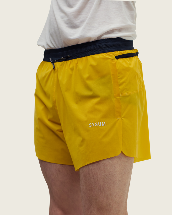 Men’s 4-inch Cordura® trail running shorts in Sap from Sysum, ultra-light stretch fabric and pocket system visible, photographed in a neutral studio setting.