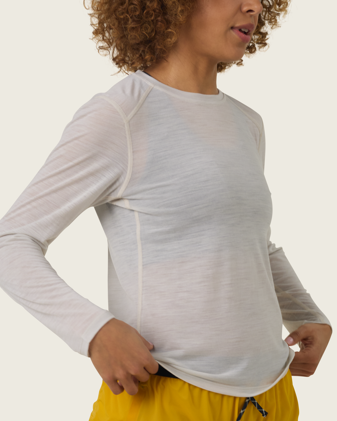 Women’s ultra-light merino long-sleeve running top in Pebble from Sysum, fine knit texture visible, photographed in a neutral studio setting.