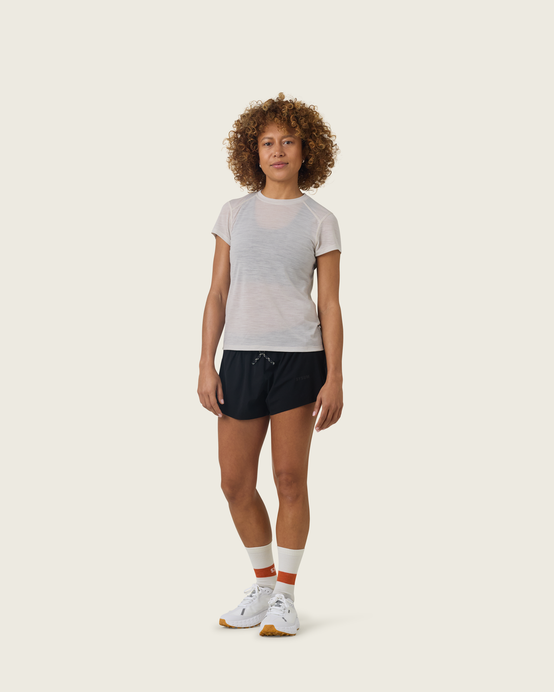 Women’s ultra-light merino short-sleeve running tee in Pebble from Sysum, fine knit texture visible, photographed in a neutral studio setting.