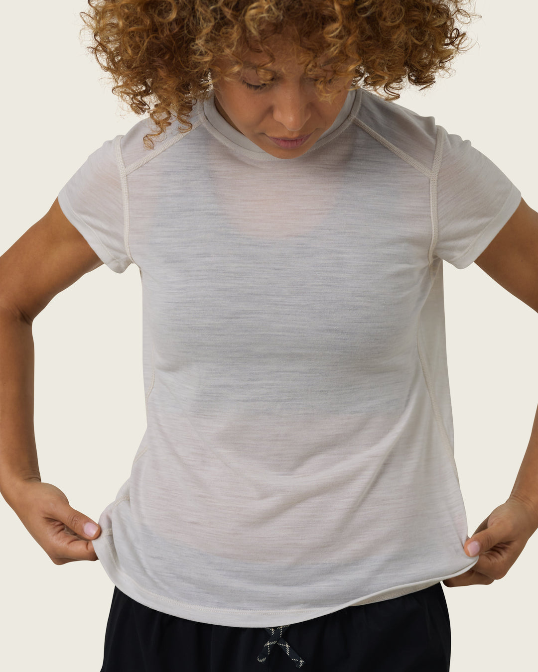 Women’s ultra-light merino short-sleeve running tee in Pebble from Sysum, fine knit texture visible, photographed in a neutral studio setting.