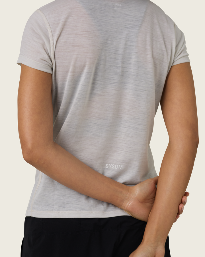 Women’s ultra-light merino short-sleeve running tee in Pebble from Sysum, fine knit texture visible, photographed in a neutral studio setting.