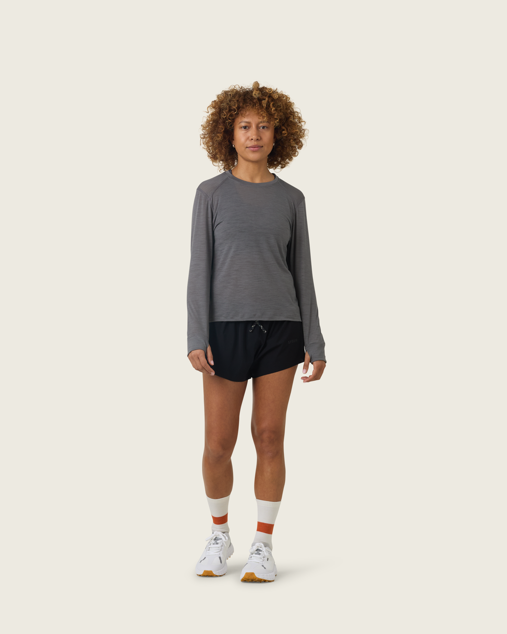 Women’s merino long-sleeve running top in Slate from Sysum, lightweight knit texture visible, photographed in a neutral studio setting.